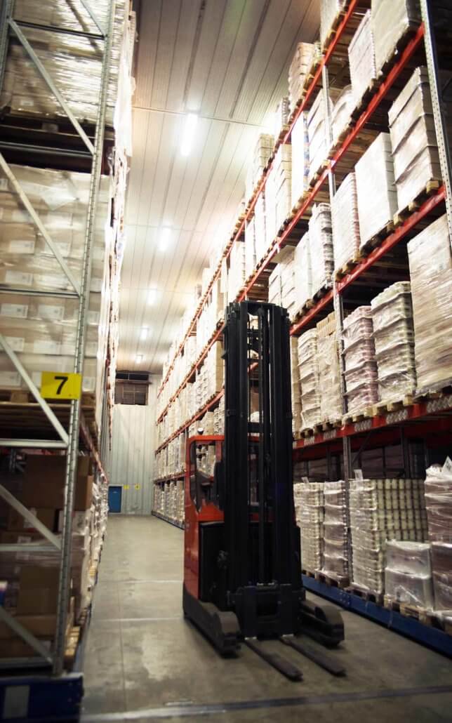 Forklift in a large warehouse with cold shelves