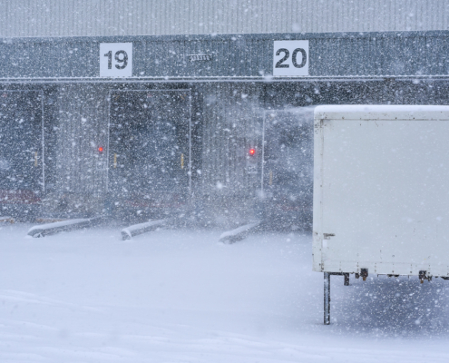 Truck hooked up to loading dock door in the snow_